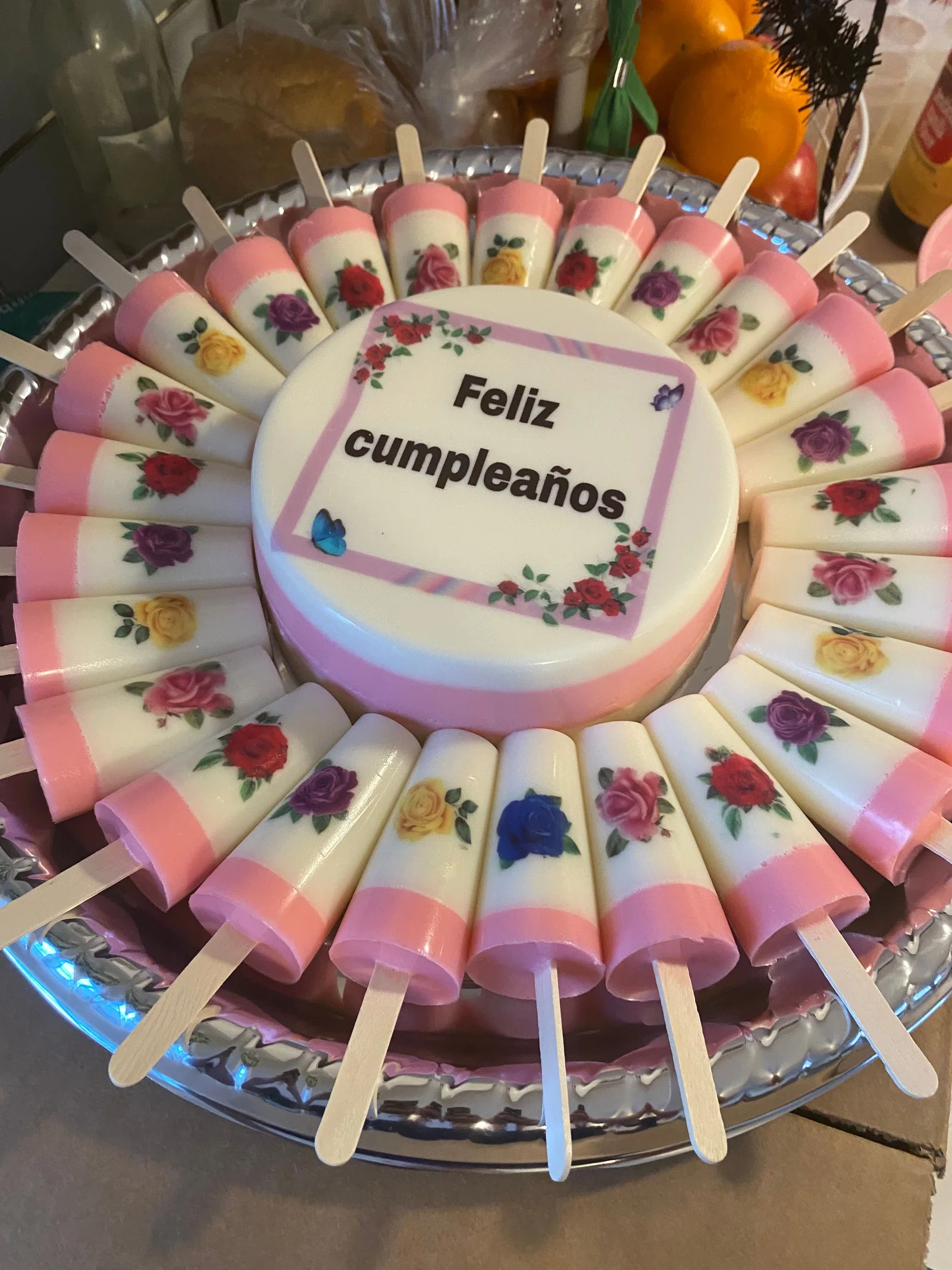 Individual birthday desserts arranged around a celebration cake