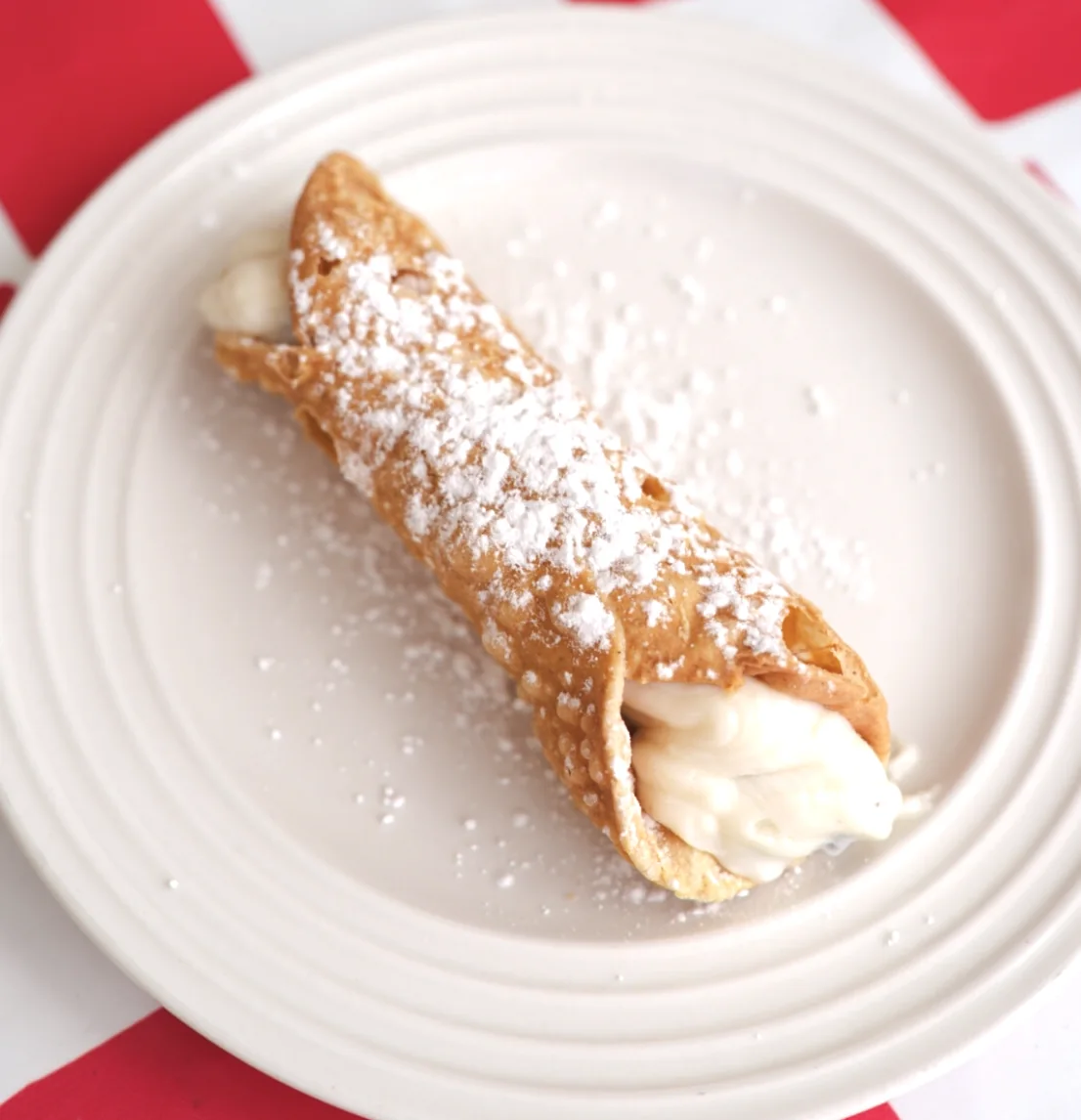 Cannoli filled with sweet cream and dusted with powdered sugar