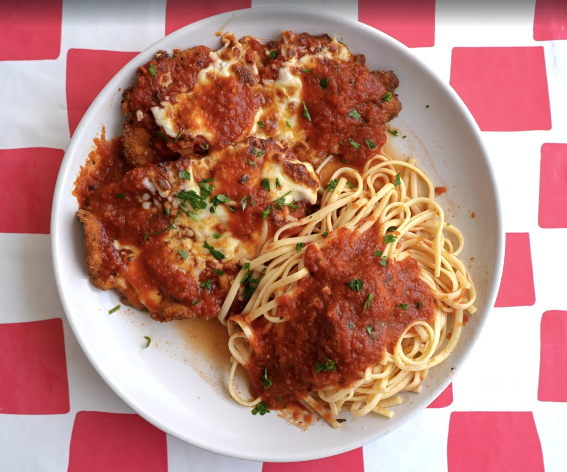 Chicken Parmesan served with linguine and tomato sauce