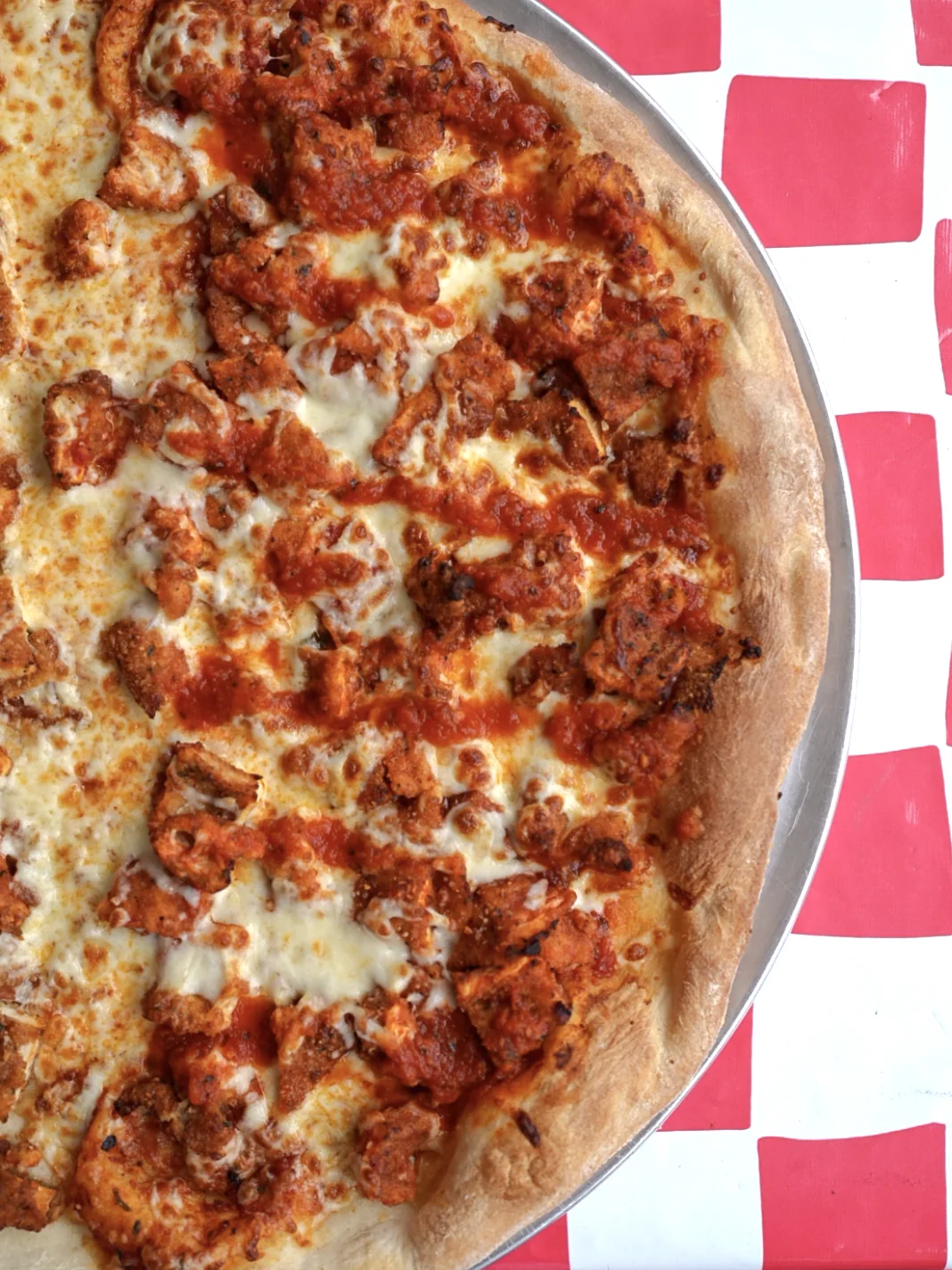 Specialty chicken pizza with melted cheese and creamy drizzle