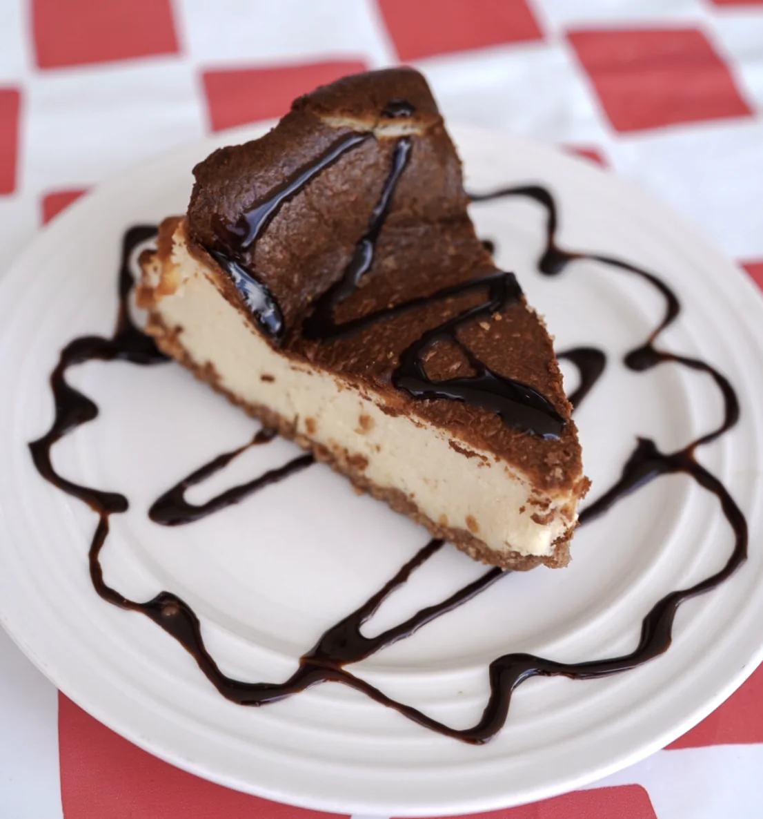 Chocolate-topped cheesecake drizzled with chocolate sauce