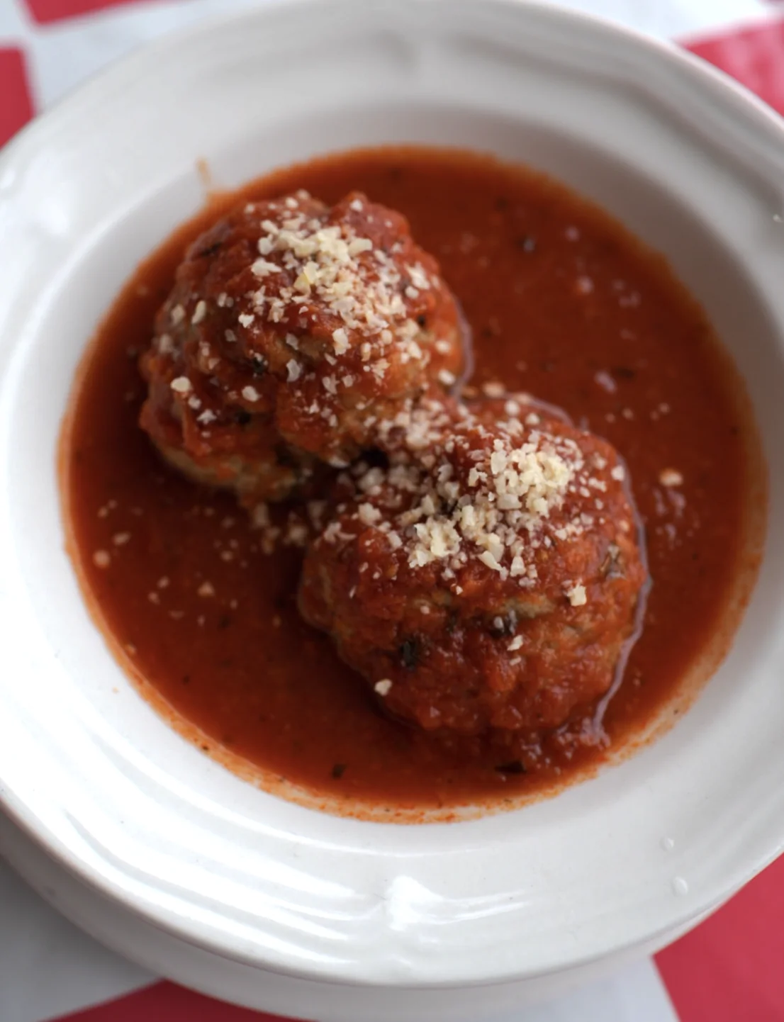 Meatballs in tomato sauce topped with grated cheese